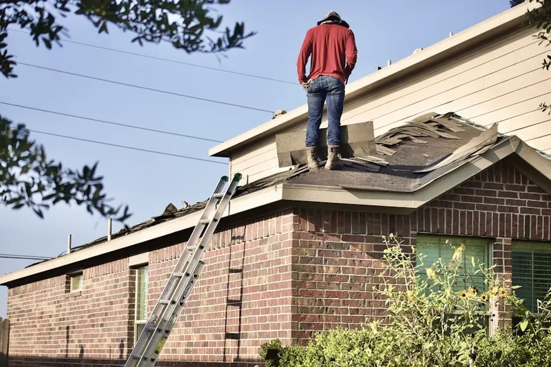 Professional roofer working on a residential roof in New Woodstock